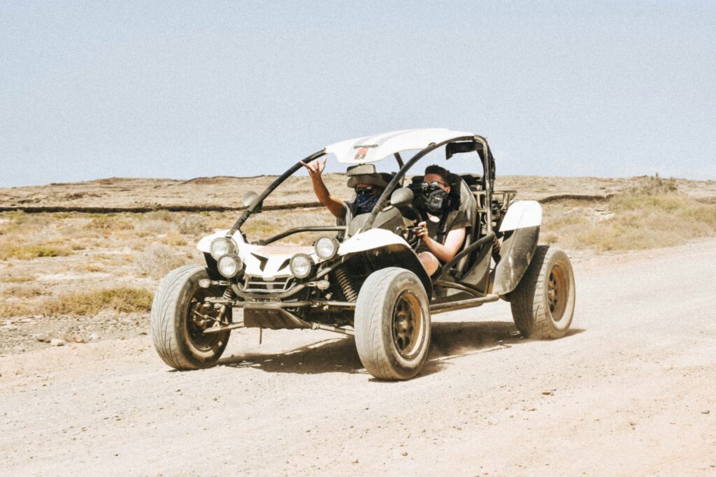 A person driving a buggy at high speed across the sandy trails of Agafay Desert